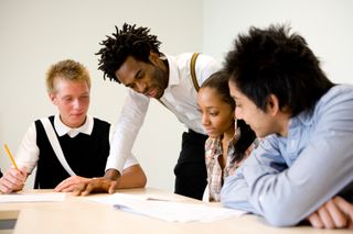 group of teenage students with tutor