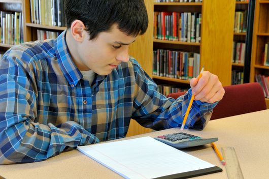 teenage boy working with calculator