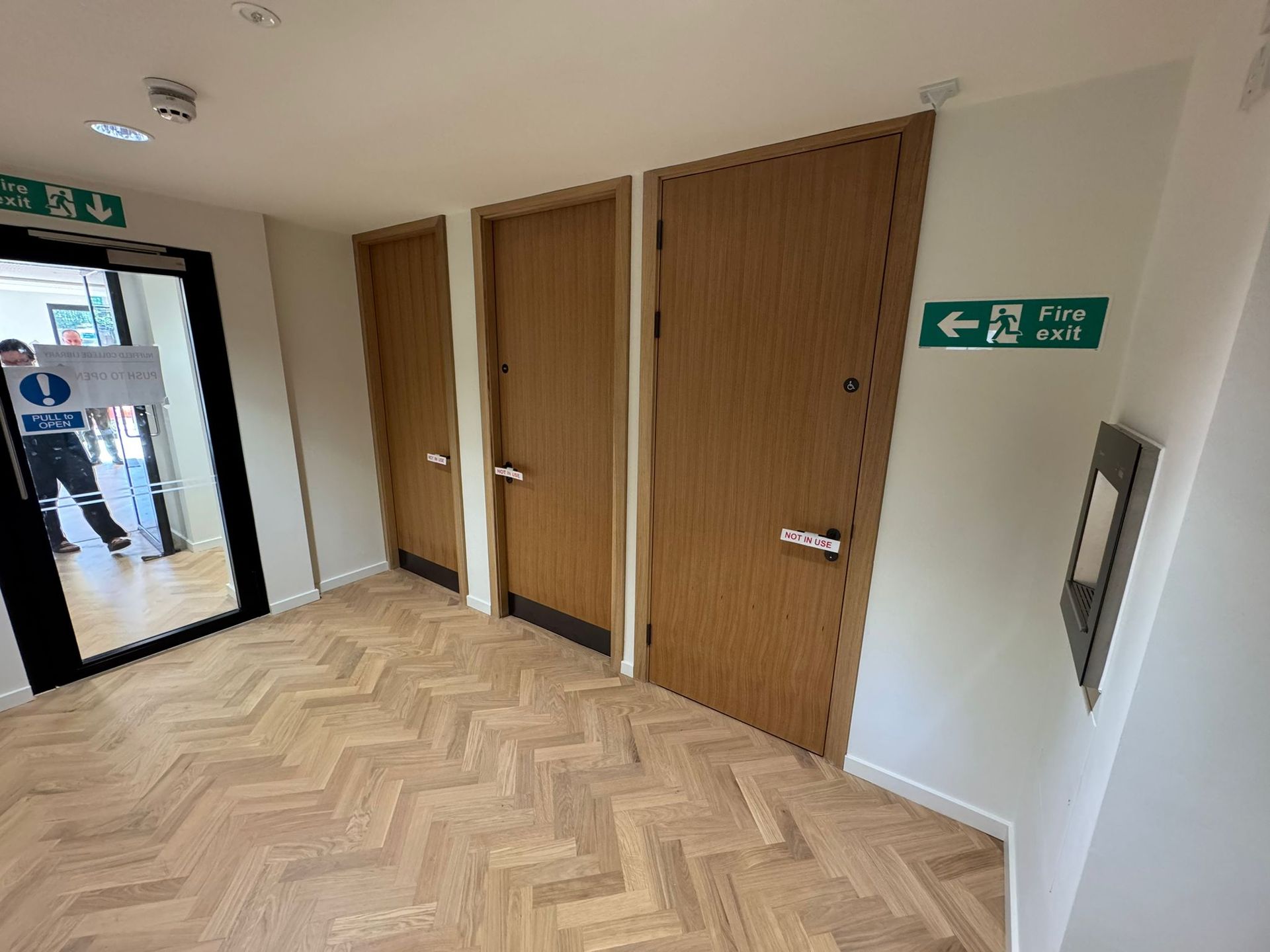 Hallway with three fire doors, and an exit sign.
