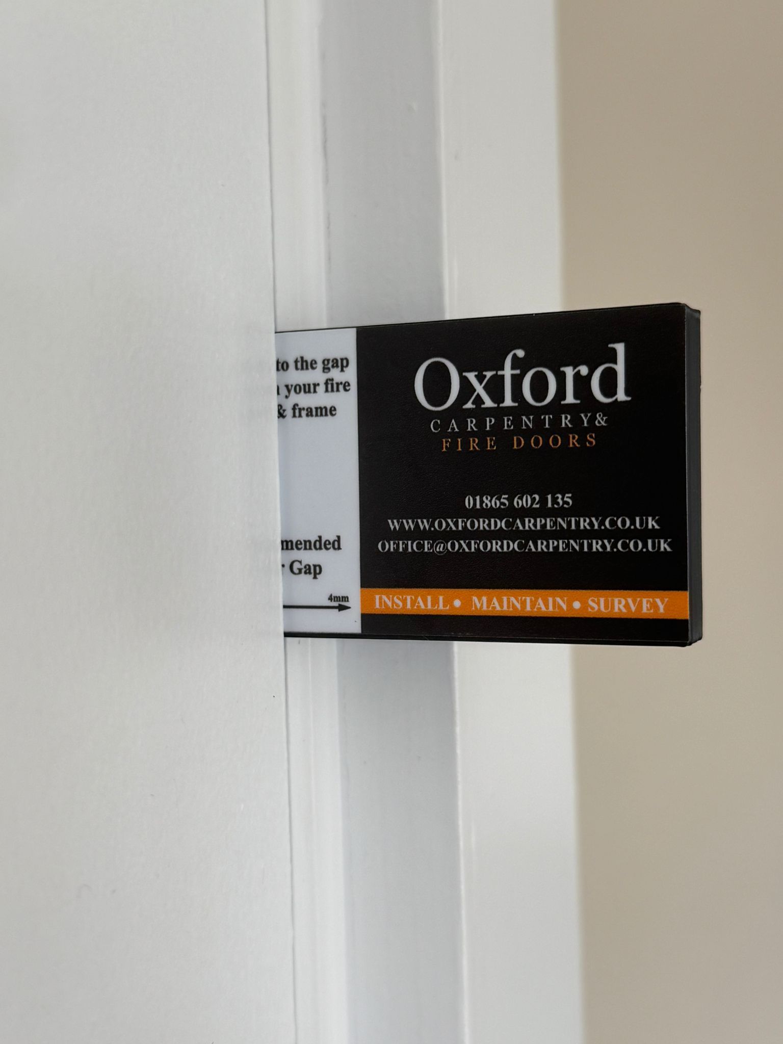 A door gap with a black Oxford gap measuring tool. 