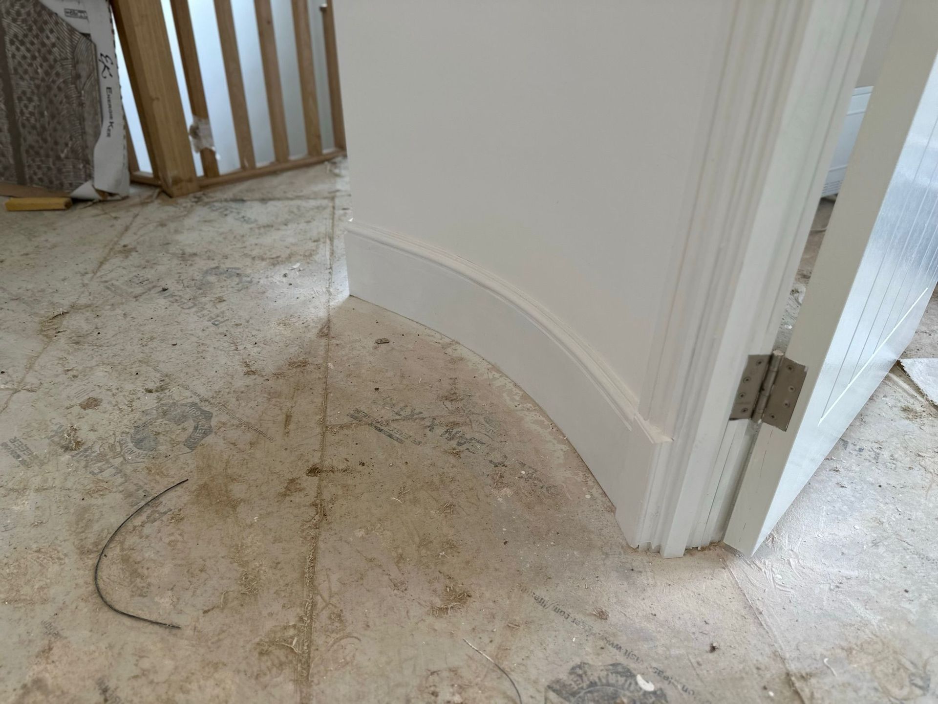 White curved molding at doorway on a concrete floor.