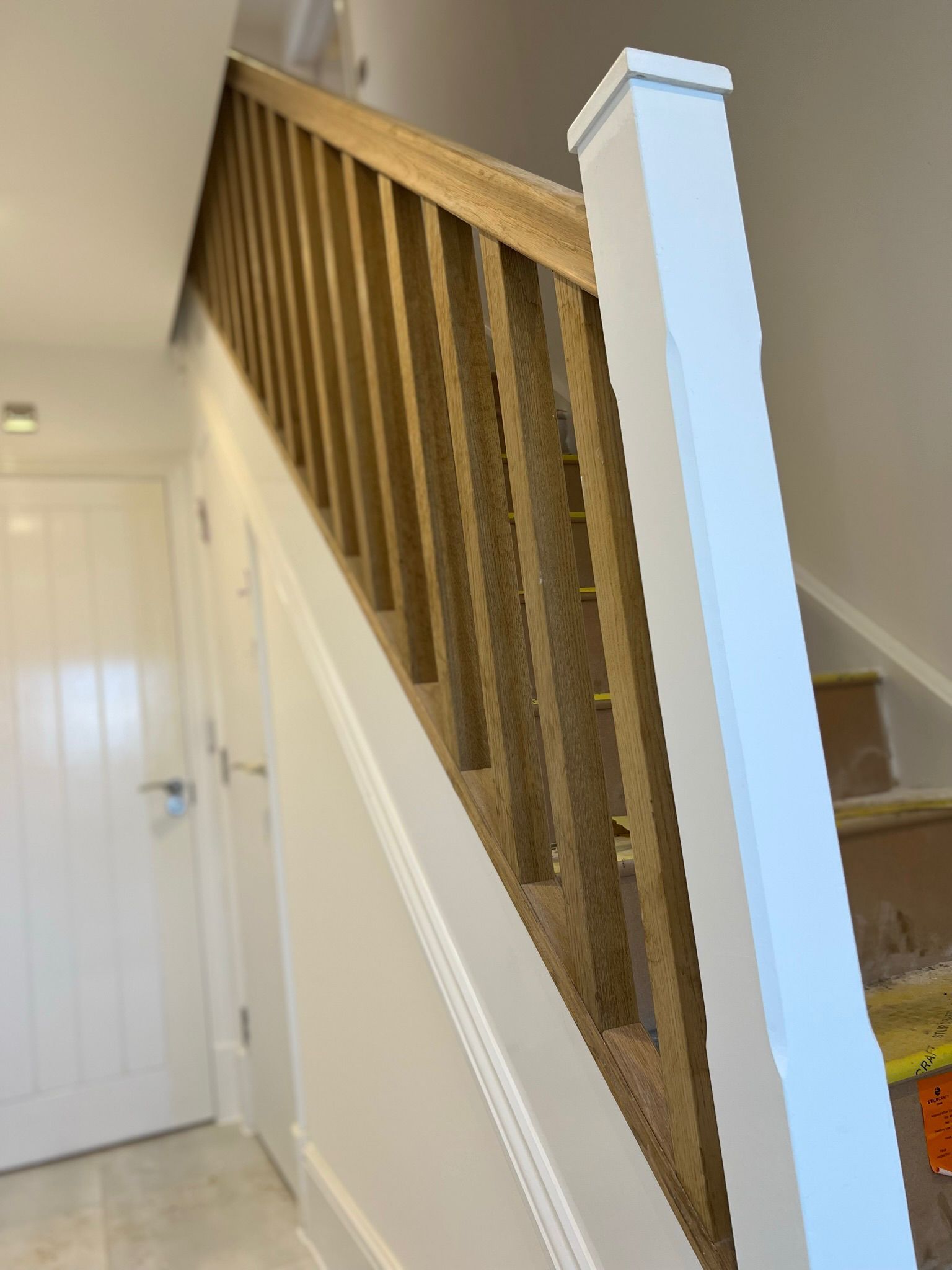 Wooden staircase with light brown balusters and white accents.