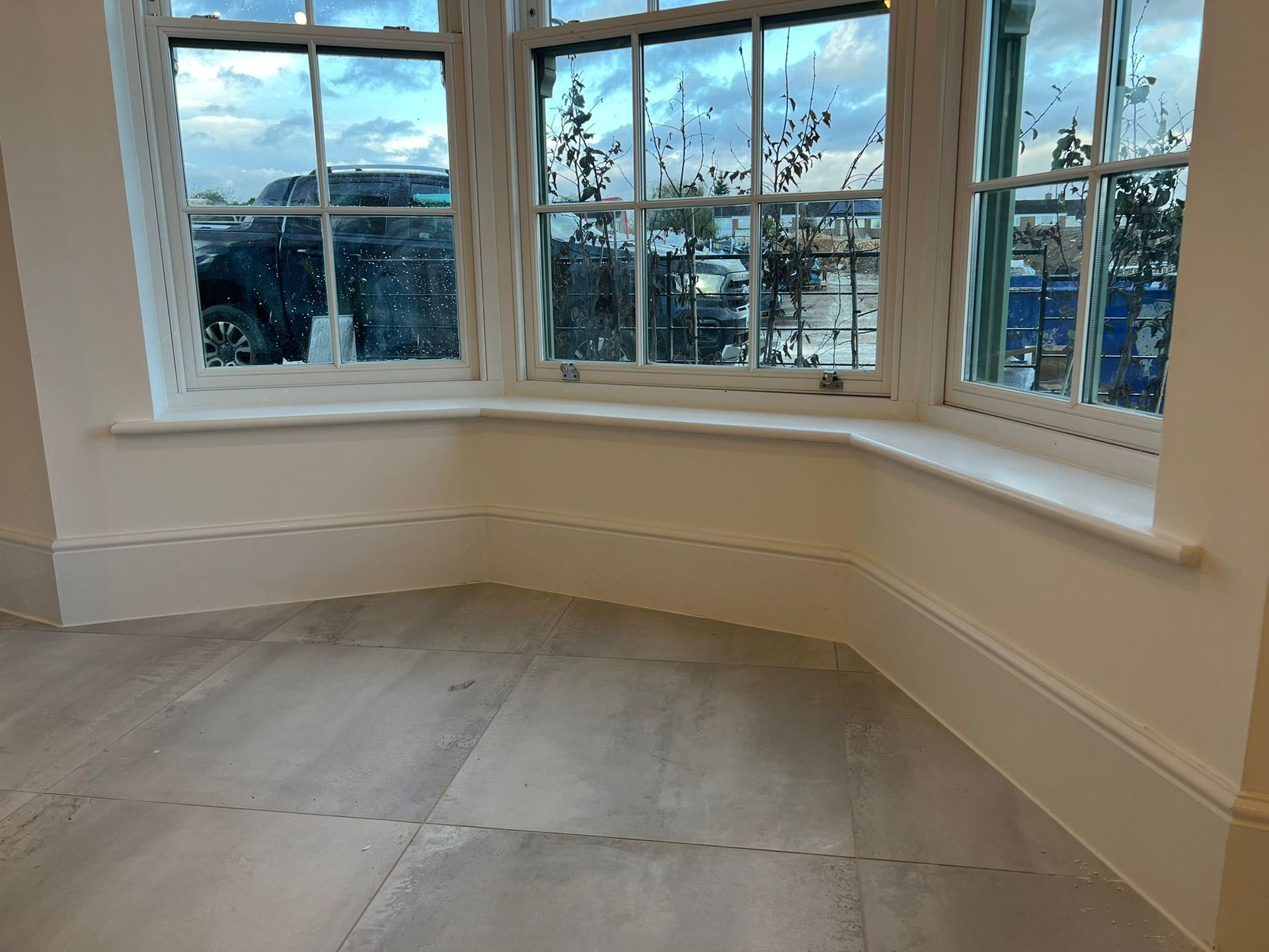 Bay window with white trim and light gray tile floor.
