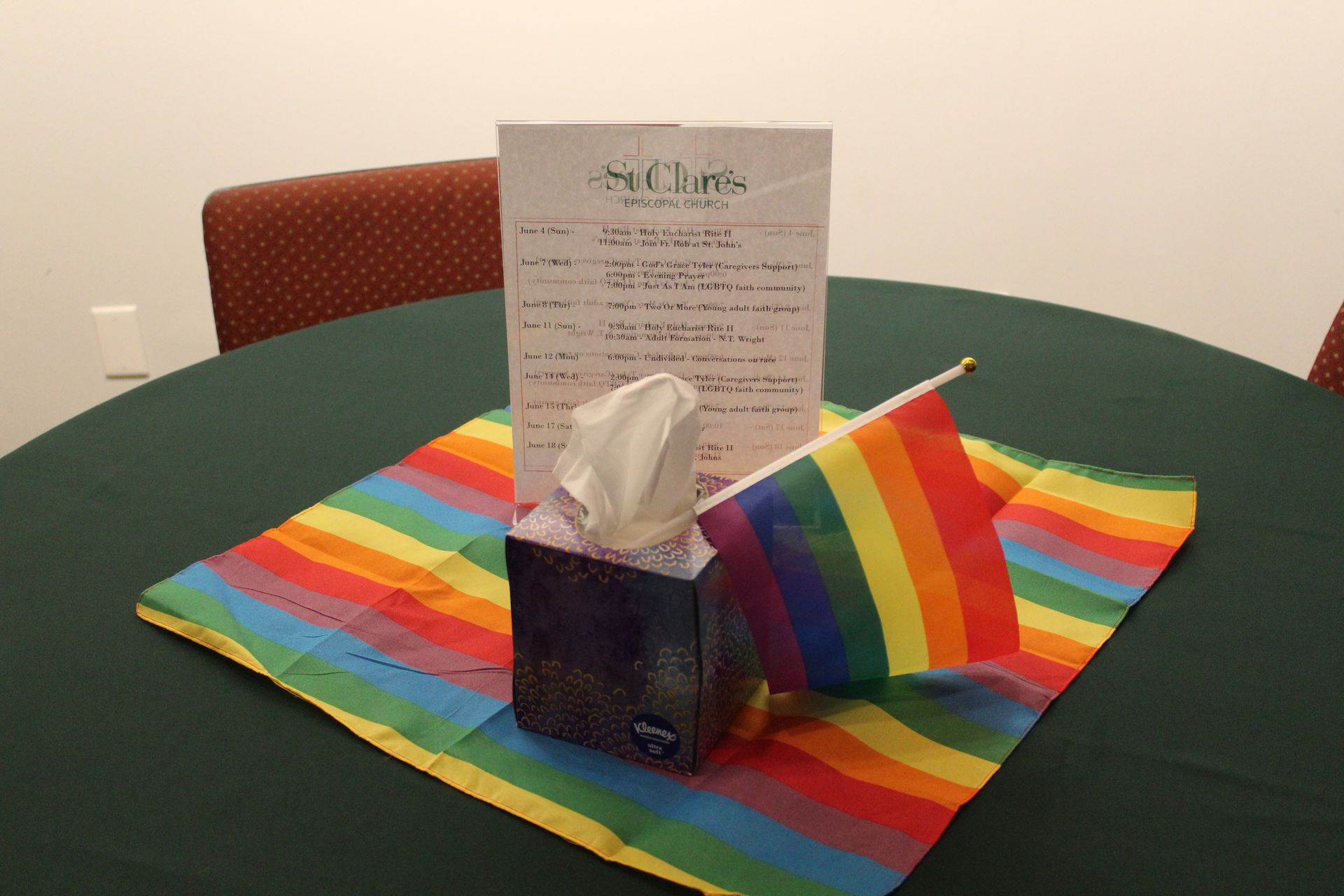 Table setting with rainbow flag, tissue box, and paper sign.