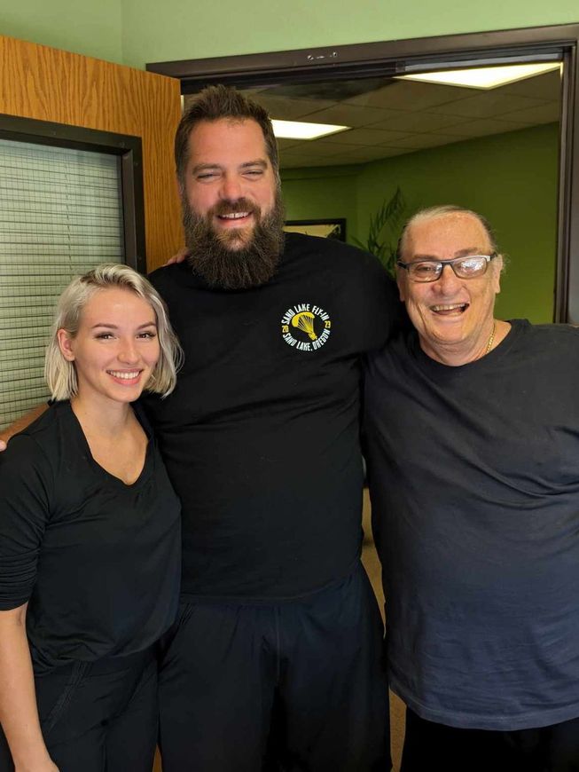 A man with a beard and two women are posing for a picture.