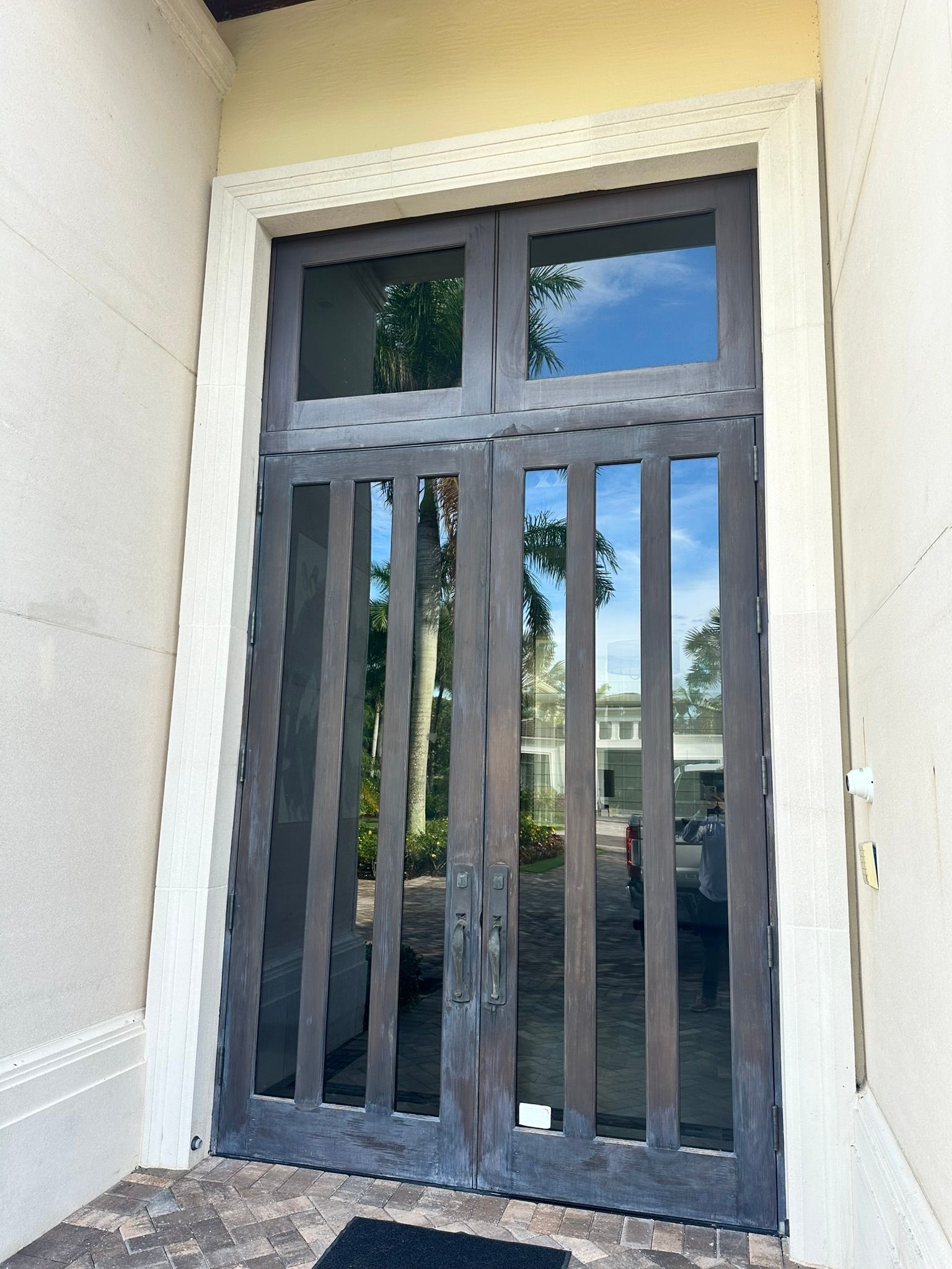 A door with a fence around it and a car parked in front of it.
