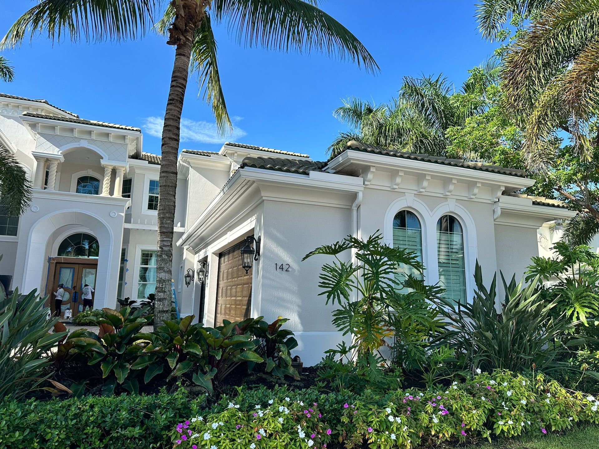 A large white house with a palm tree in front of it