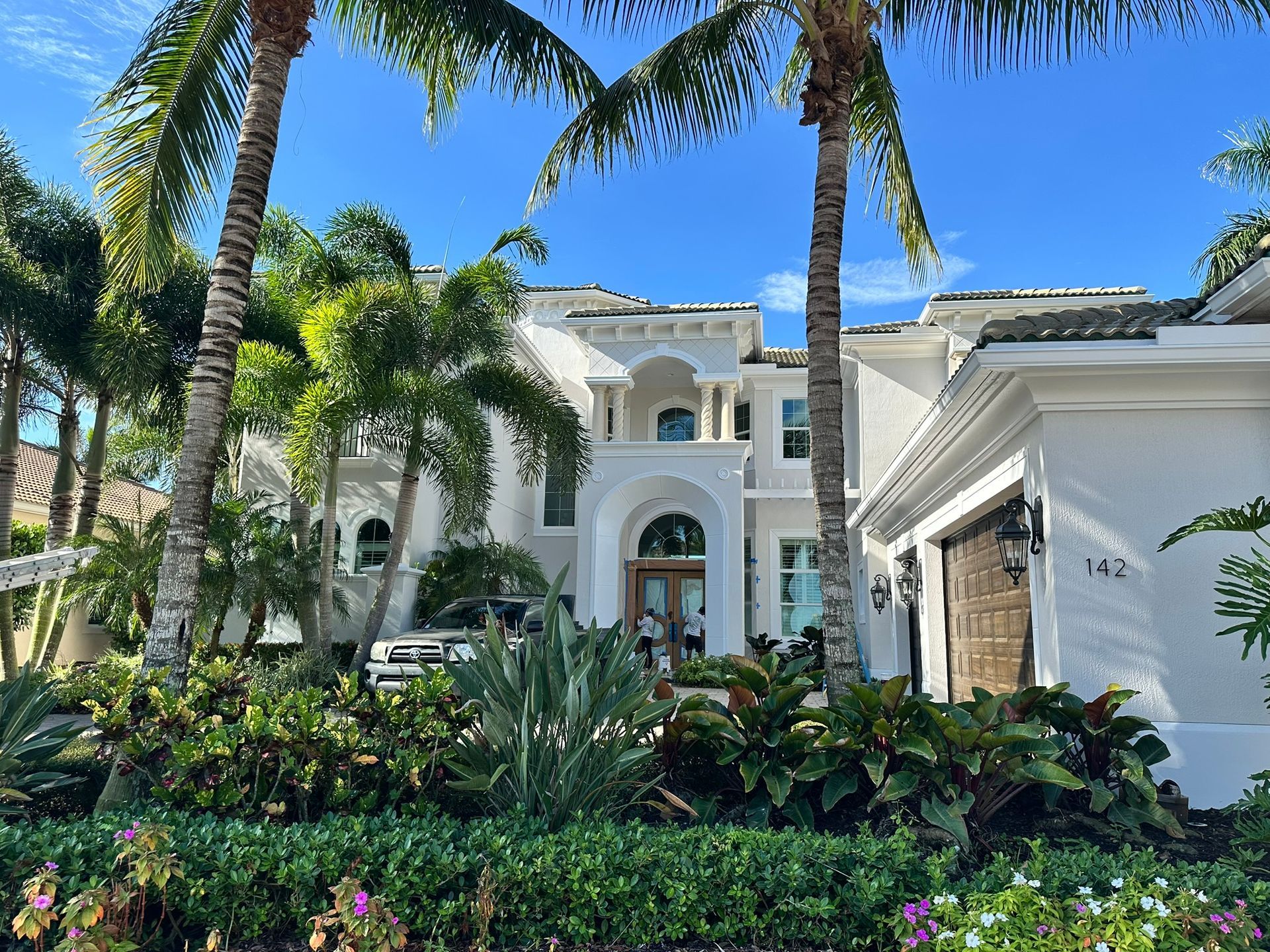 A large white house with palm trees in front of it
