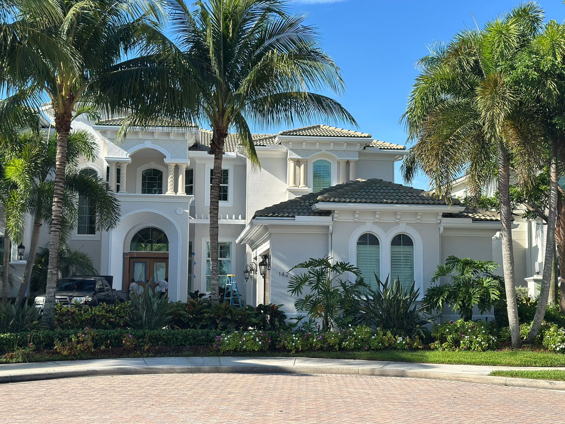 A large white house with palm trees in front of it