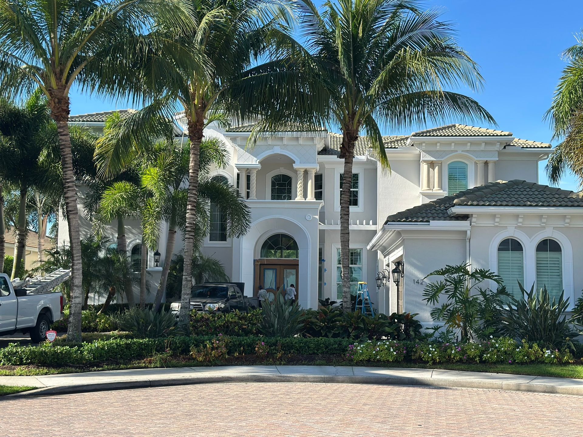 A large white house with palm trees in front of it