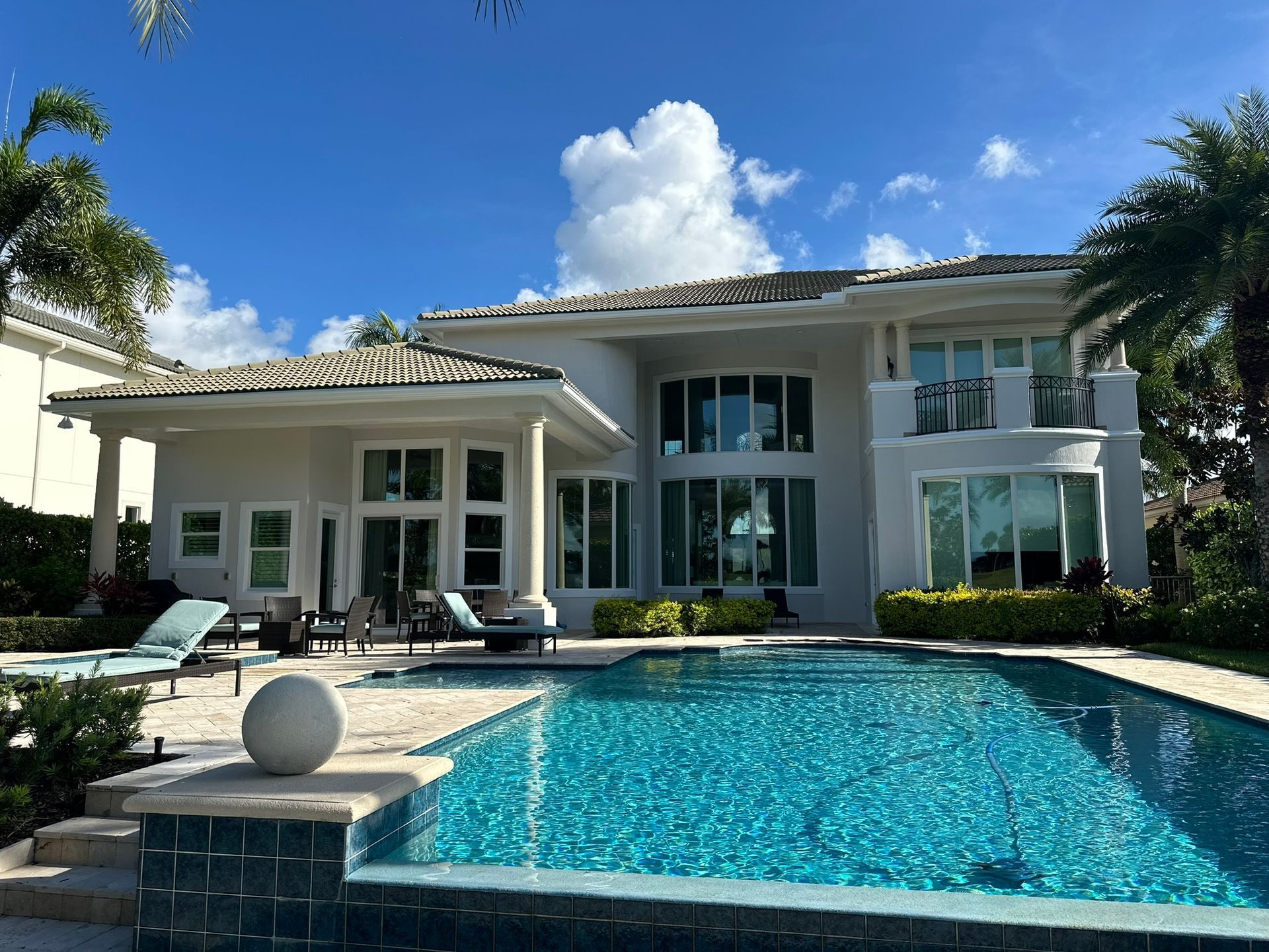 A large white house with a large swimming pool in front of it