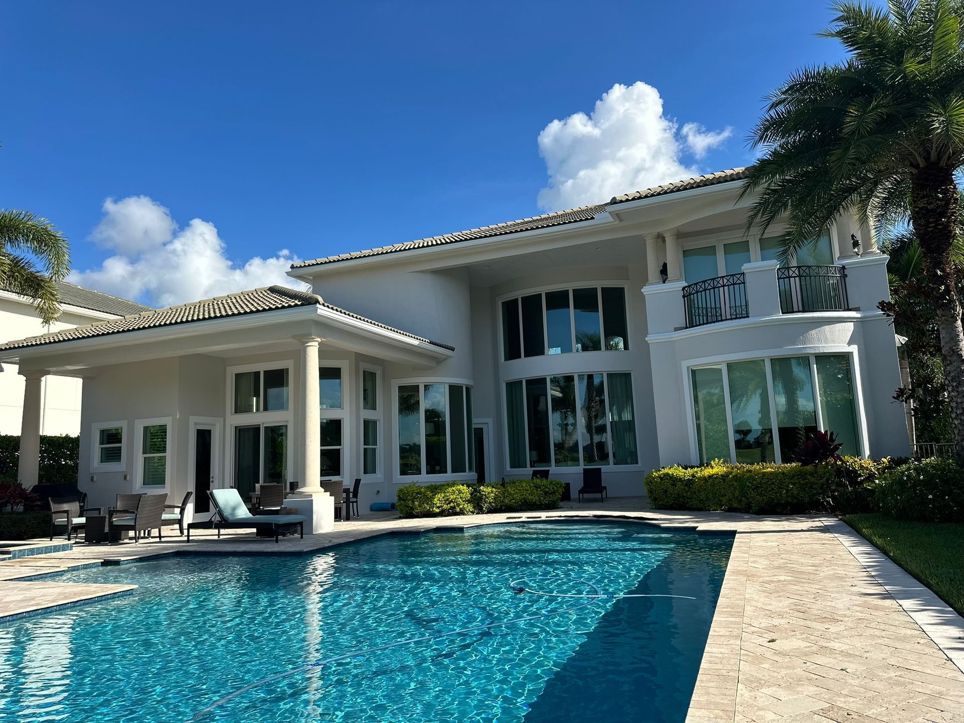 A large white house with a swimming pool in front of it