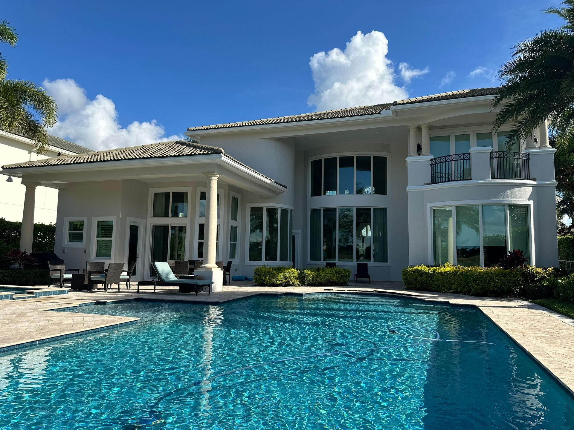 A large white house with a large swimming pool in front of it