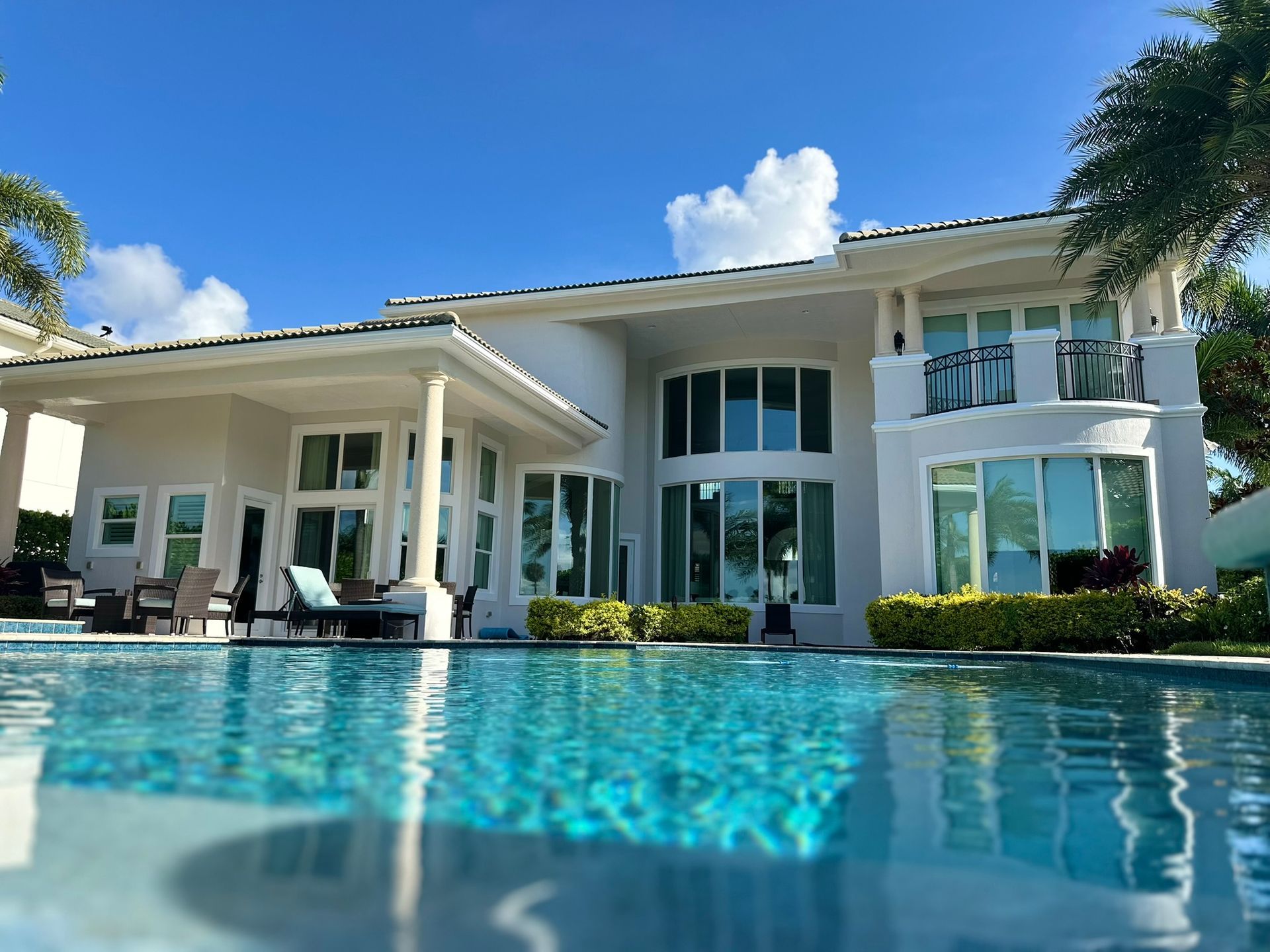 A large white house with a swimming pool in front of it