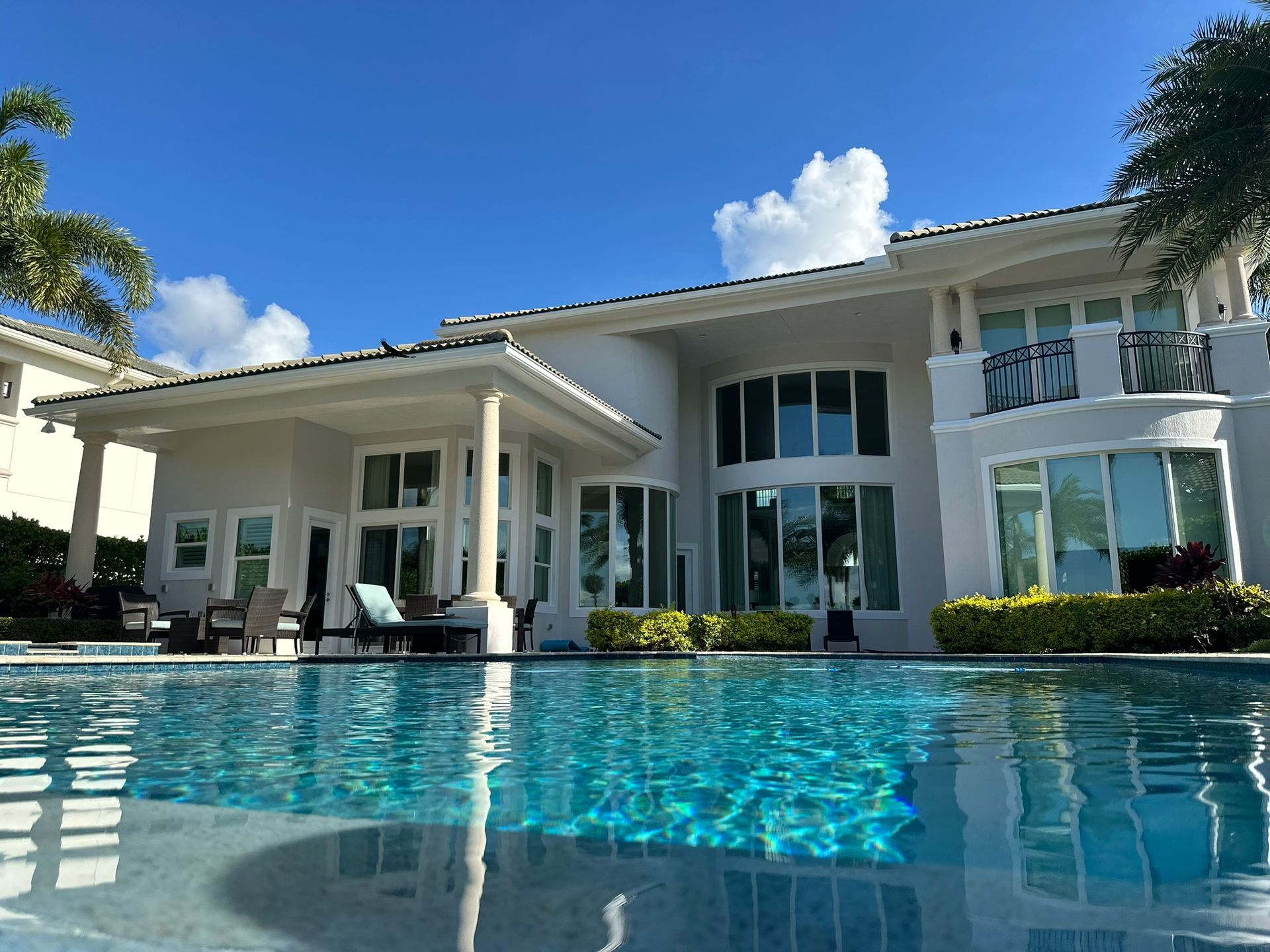 A large white house with a swimming pool in front of it