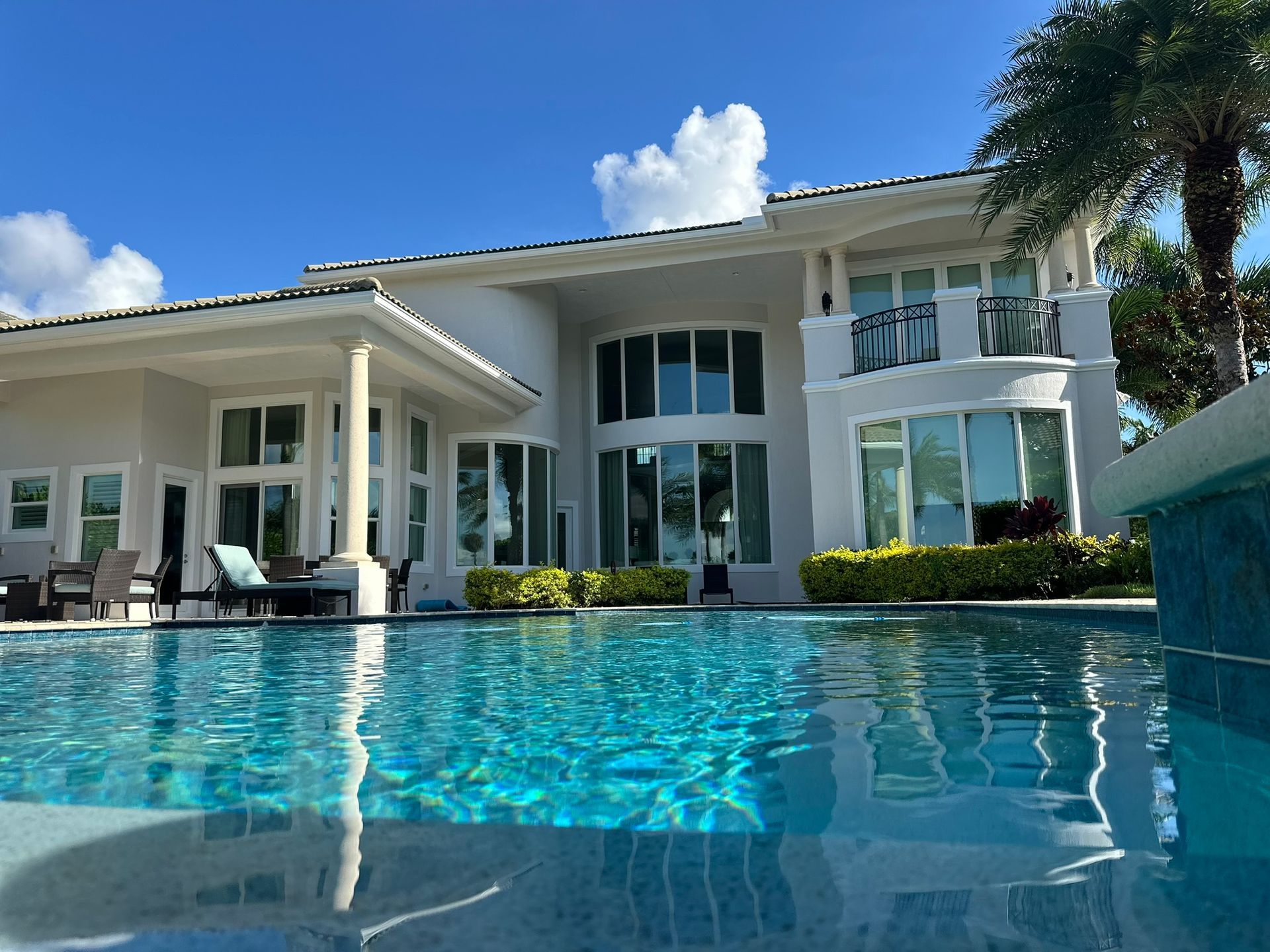 A large white house with a swimming pool in front of it