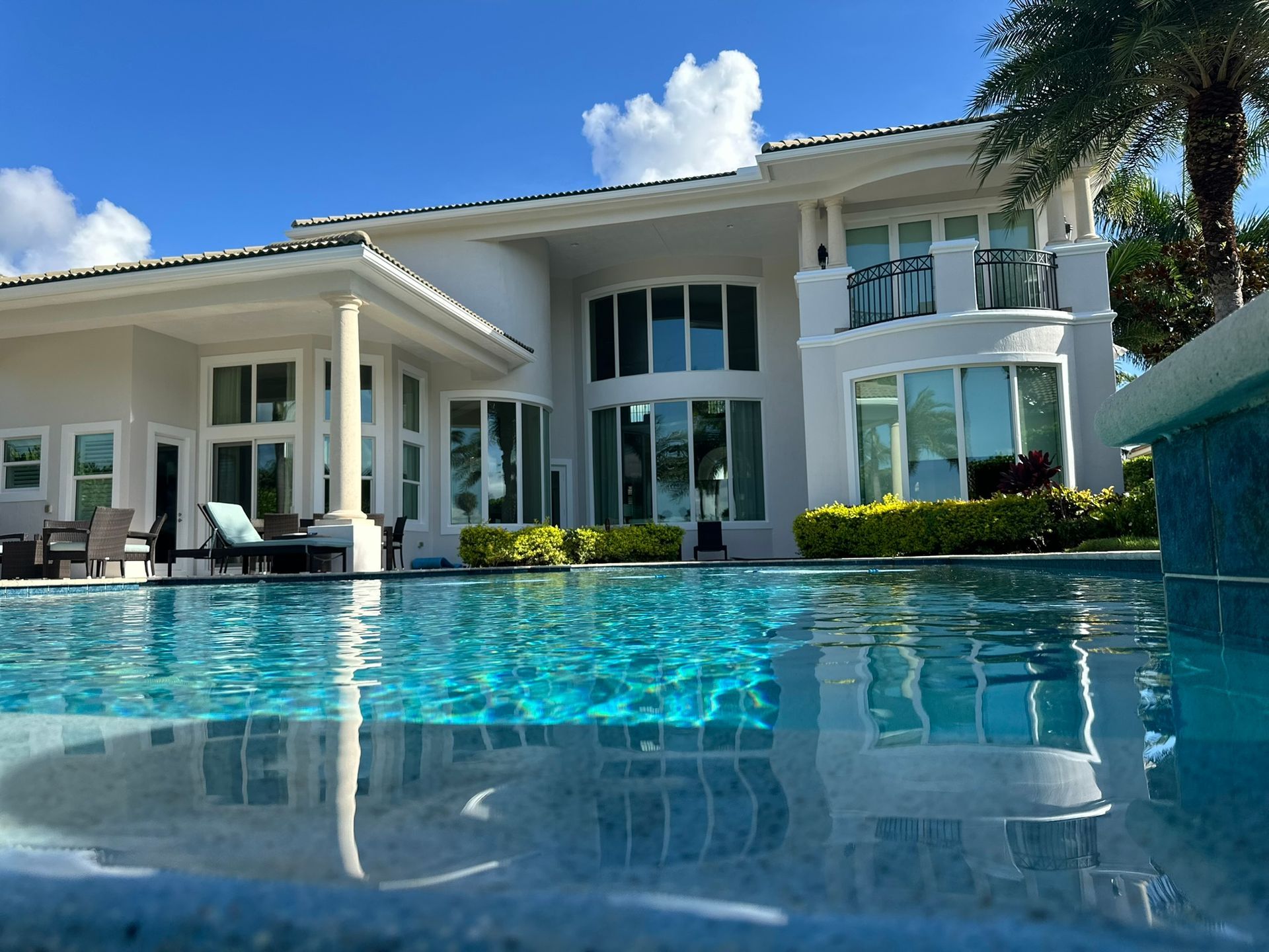 A large white house with a swimming pool in front of it