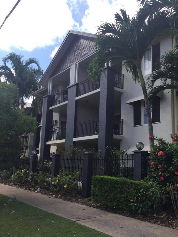 A large white building with a black fence around it — Pete's Painting Solutions In Cairns North, QLD