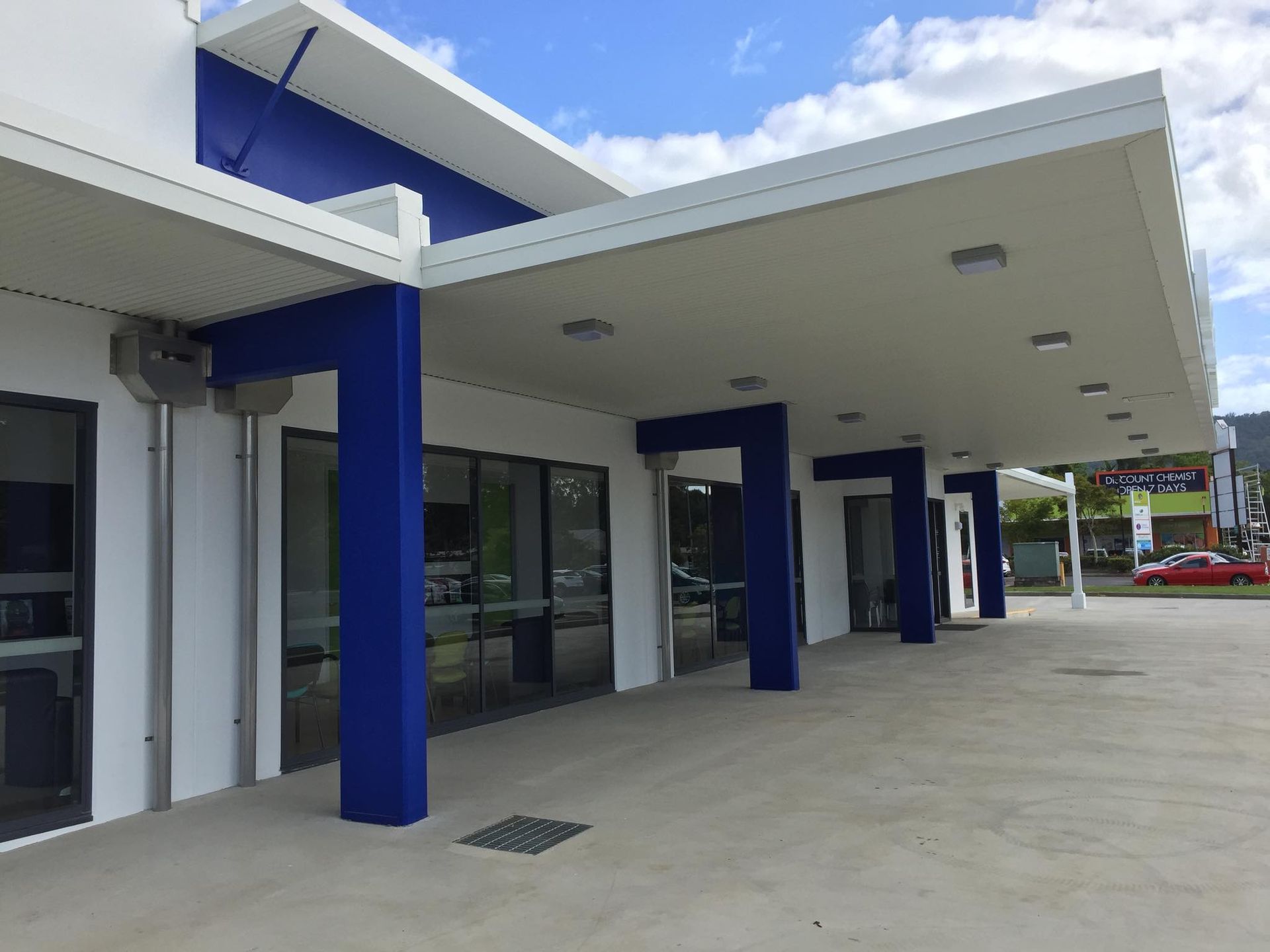 Two Men Are Painting The Side Of A Building On Scaffolding — Pete's Painting Solutions In Palm Cove, QLD