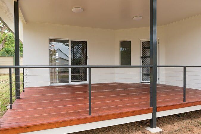 A Porch With A Wooden Deck And A Black Railing — Pete's Painting Solutions In Cairns City, QLD