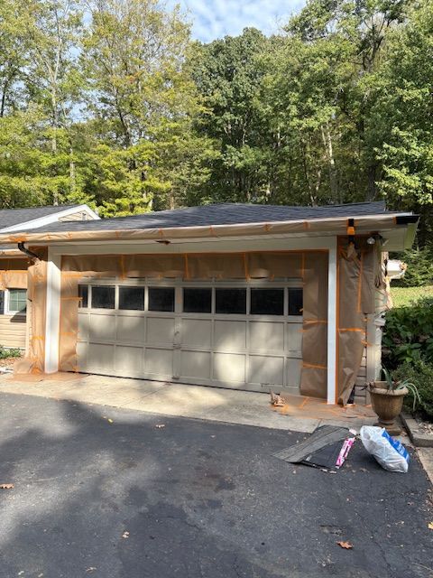 Garage under construction with exposed insulation. Garage door and roof are visible.