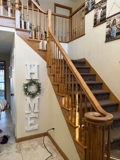 Wooden staircase with carpeted steps in a home. 