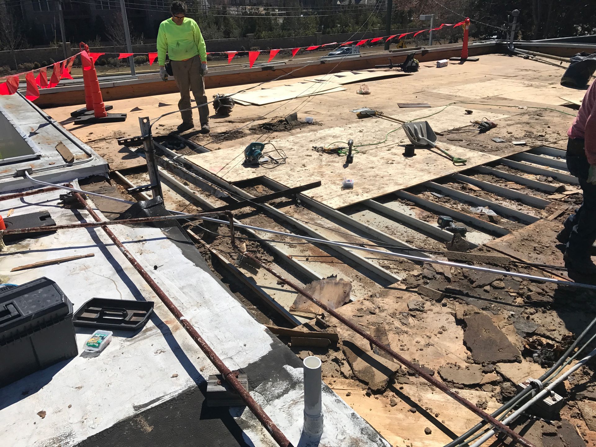 Construction site with exposed beams and piping, workers present.