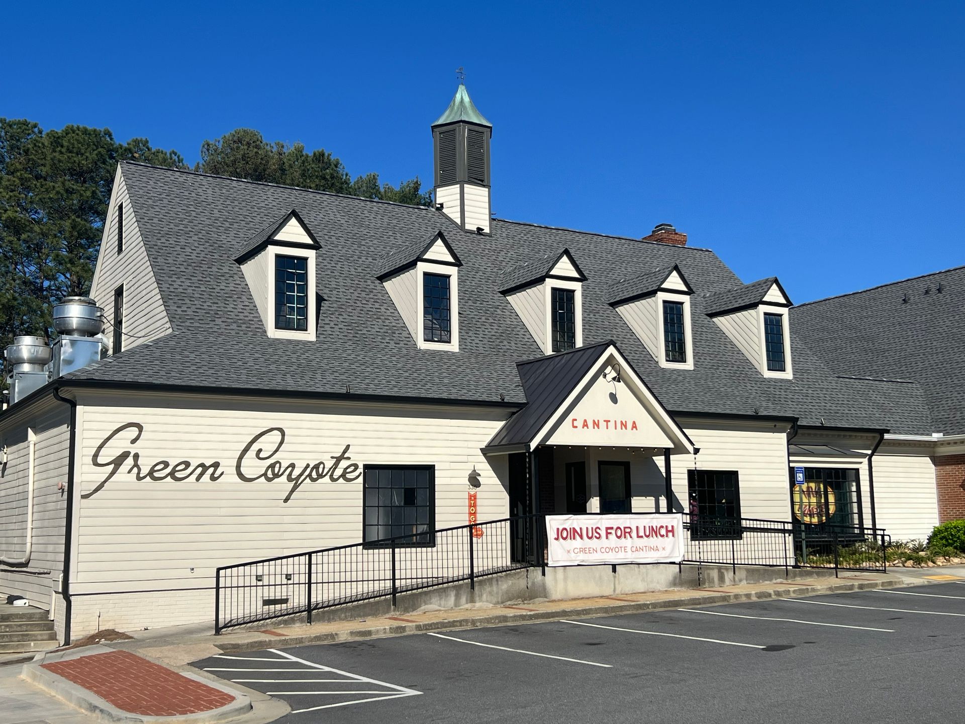 Green Coyote restaurant exterior, white building with gray roof, handicap ramp, sign above entrance.