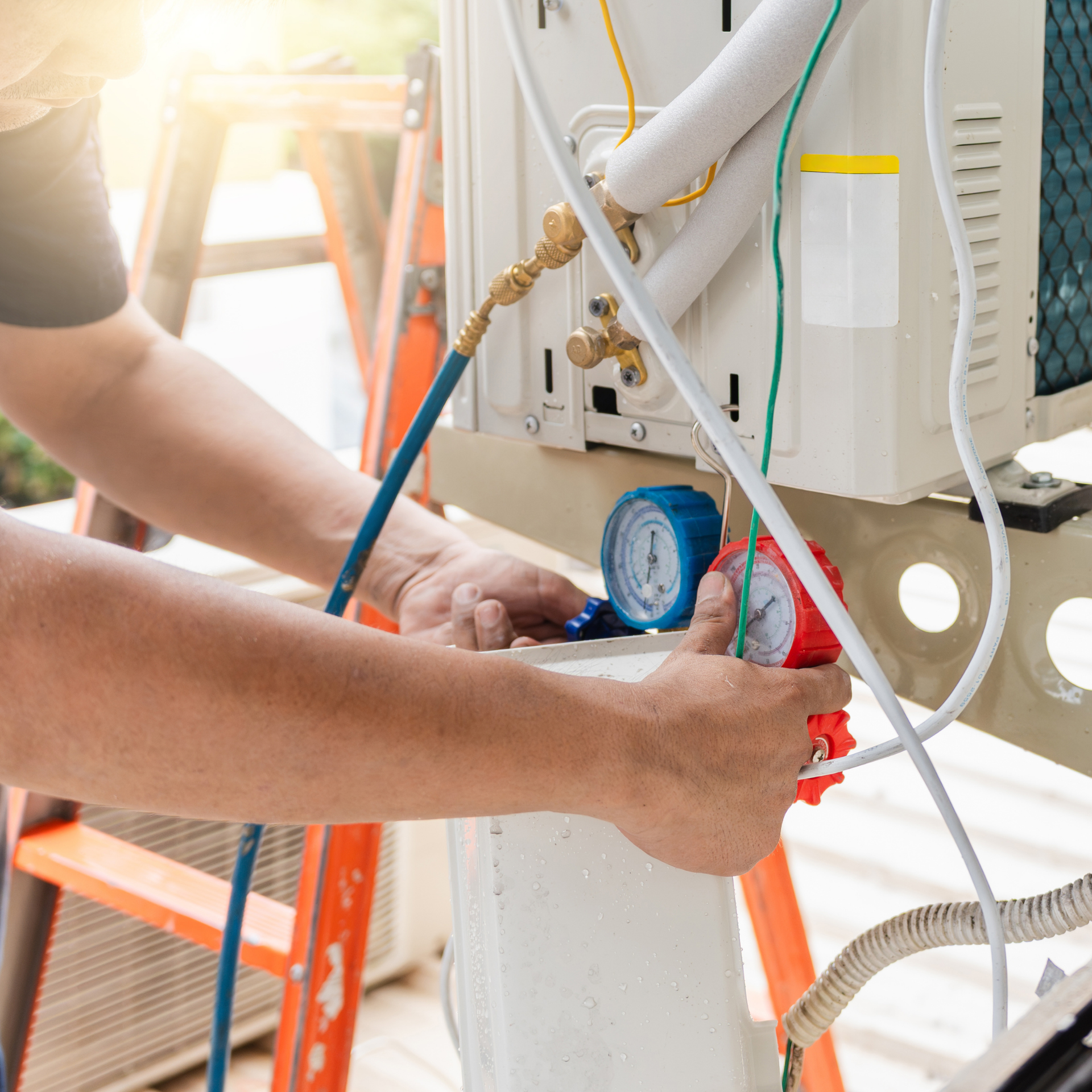 Technician repairing an AC unit, using gauges and tools outdoors.