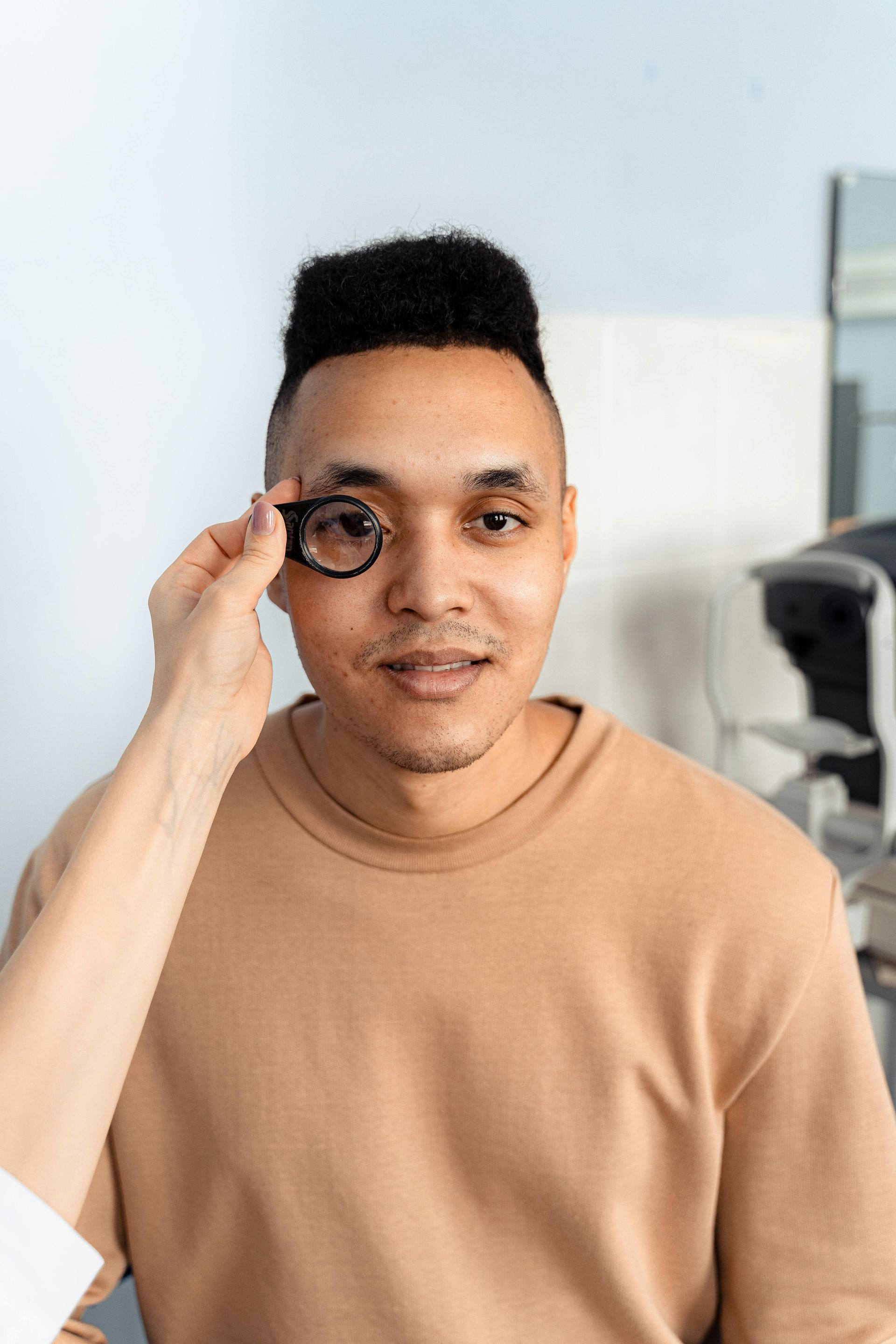 Man getting an eye exam. An eye doctor holds a lens in front of his eye in a doctor's office.