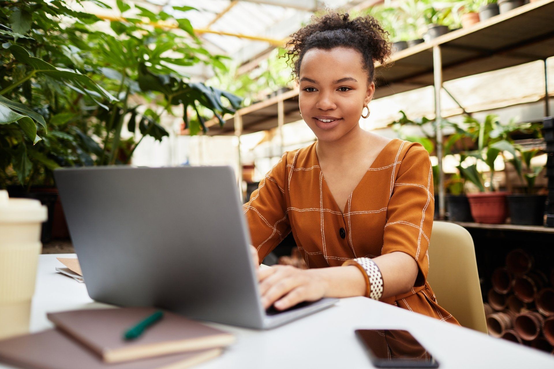 Young professional smiling woman working at desk and laptop inside a nursery