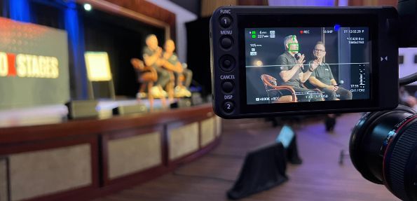 A man is taking a picture of a group of people holding hands on an ice rink