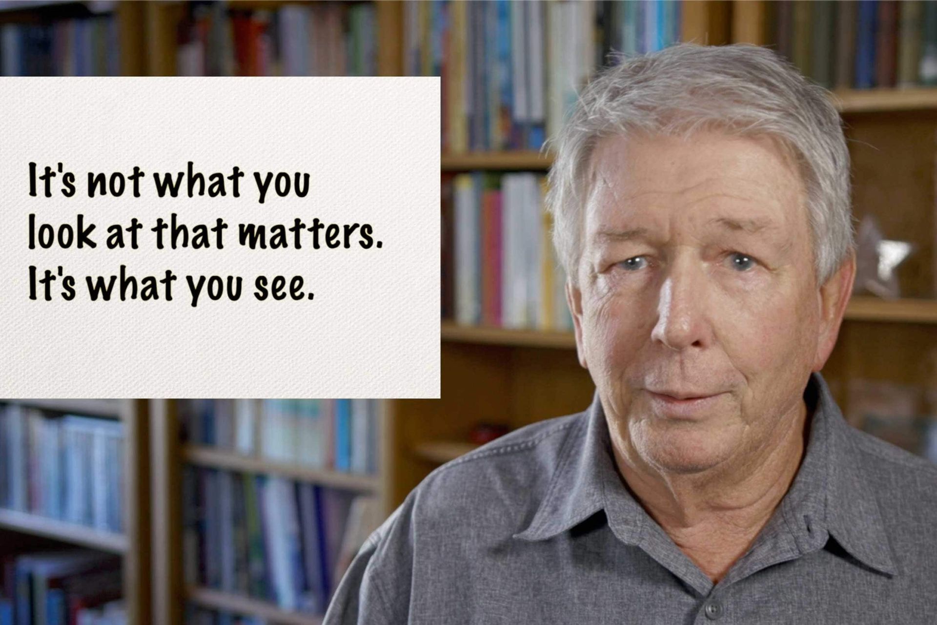 An older man stands in front of a bookshelf with a sign that says it 's not what you look at that matters.