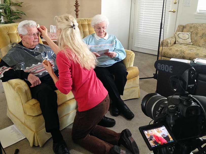 A woman is kneeling in front of a rode camera