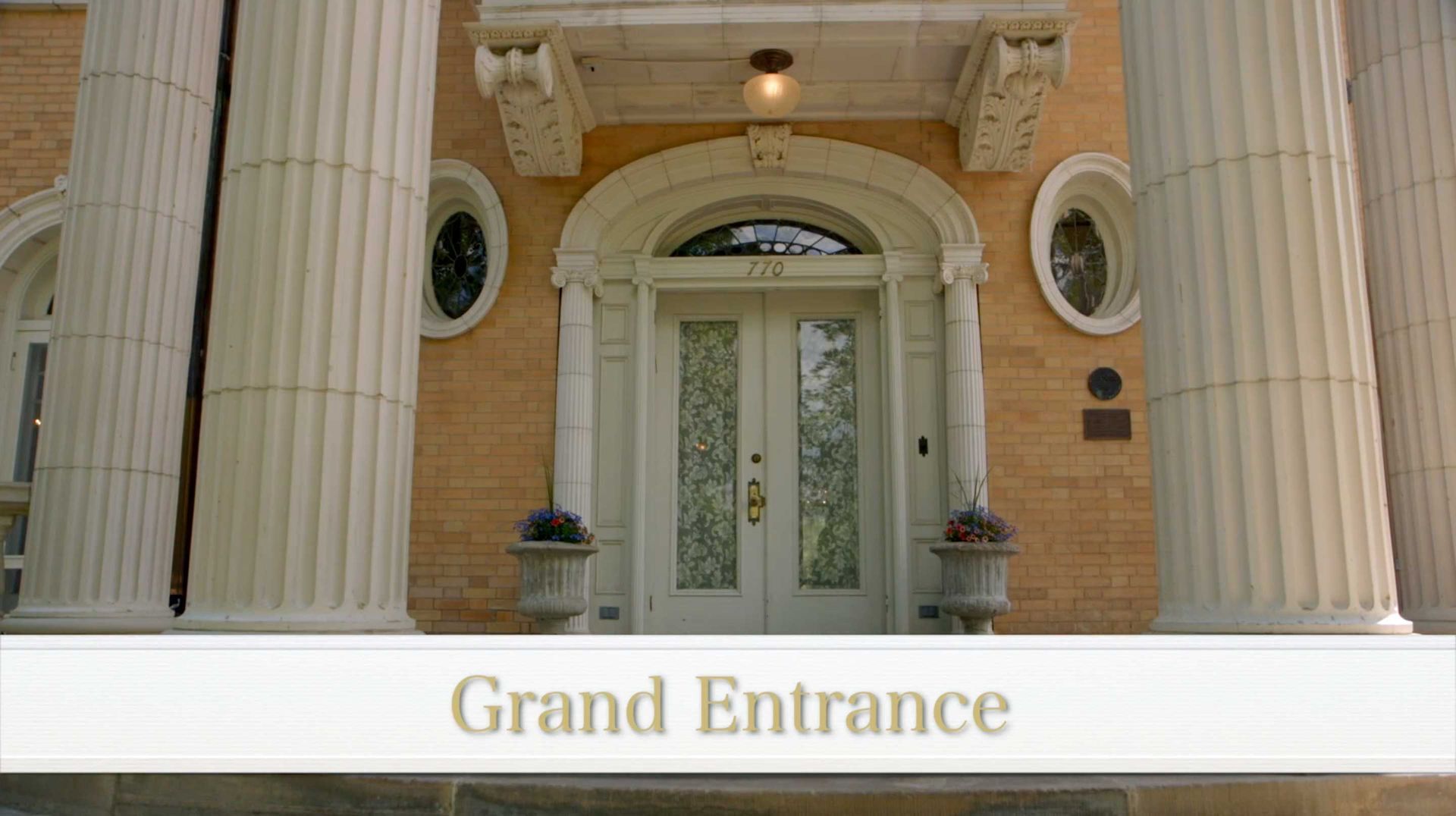 A large brick building with columns and a grand entrance.