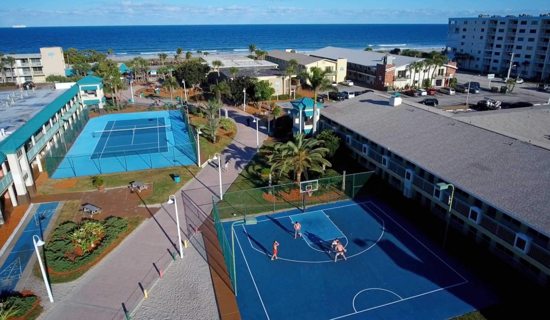 An aerial view of a tennis court and a basketball court