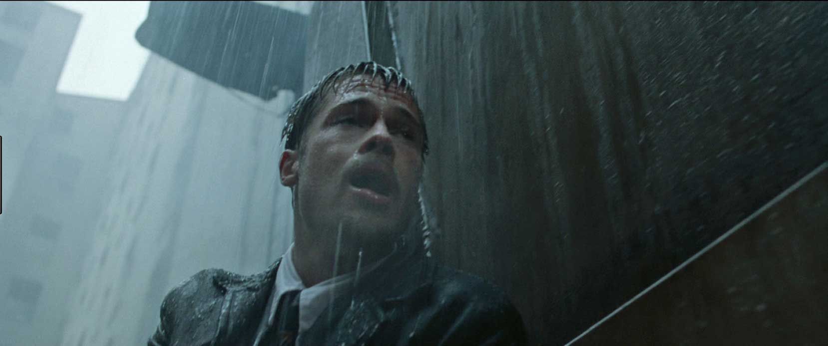 A man in a suit and tie is standing in the rain.