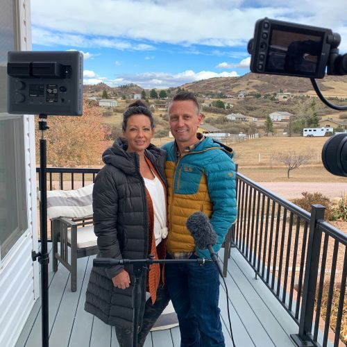 A man and a woman are posing for a picture on a balcony