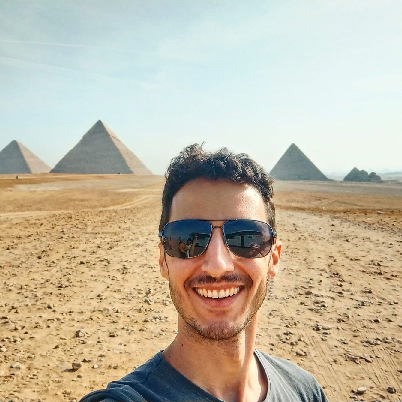 Um homem de camisa xadrez está sentado em uma cadeira azul