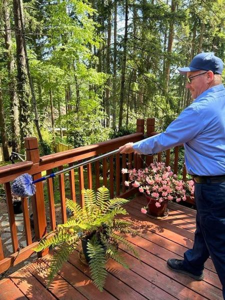 A man is cleaning a deck with a mop.