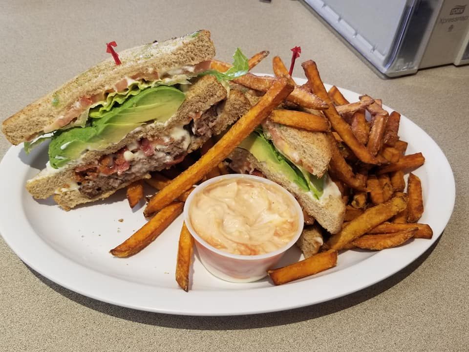 A white plate topped with a sandwich and french fries