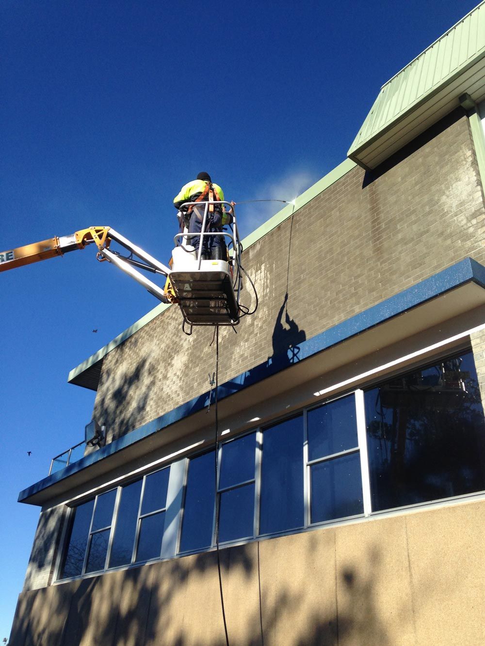 Man Cleaning Roof Using Pressure Washer
