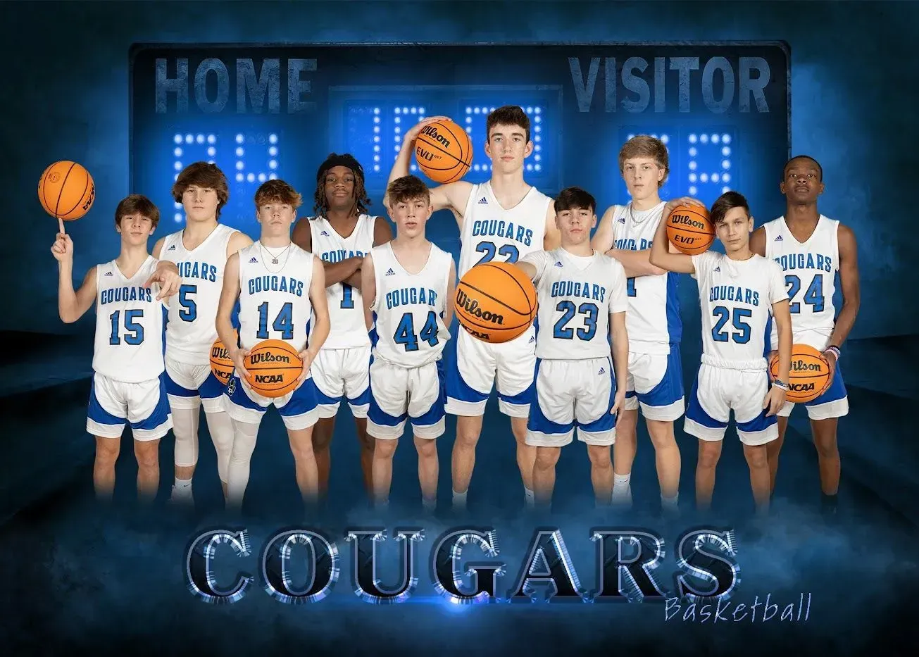 A group of young men are standing next to each other holding basketballs in front of a scoreboard.
