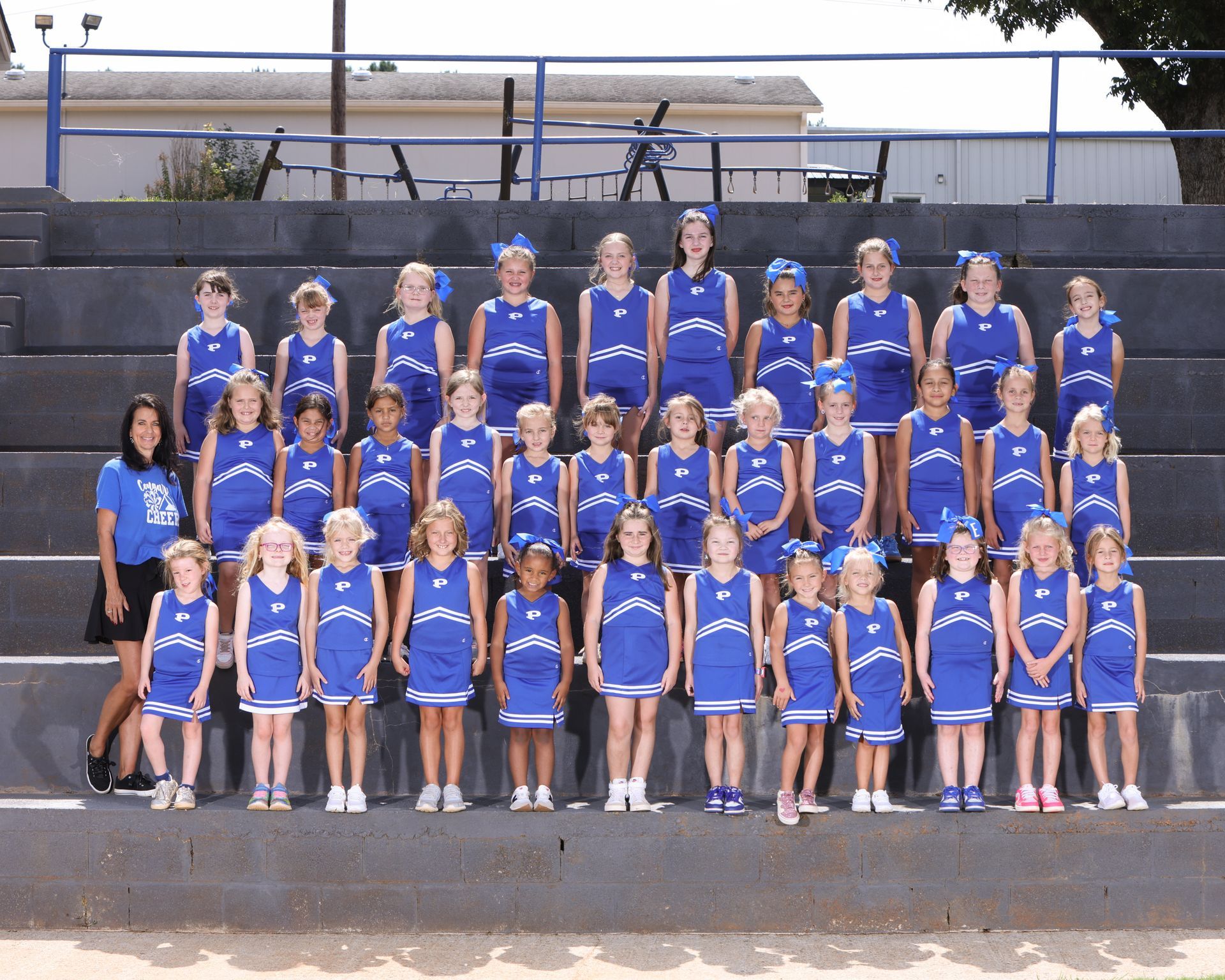 A group of cheerleaders are posing for a team photo.