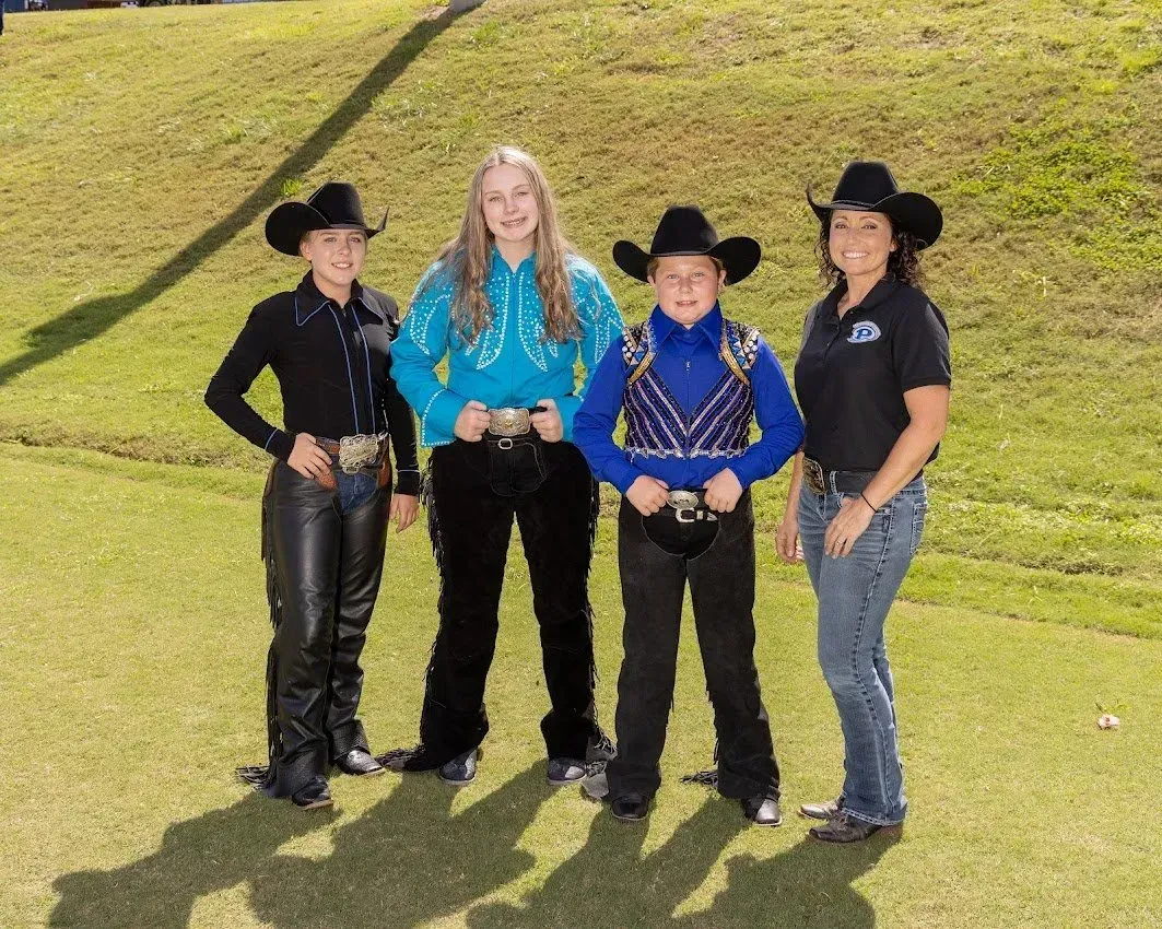 A group of people wearing cowboy hats are posing for a picture.