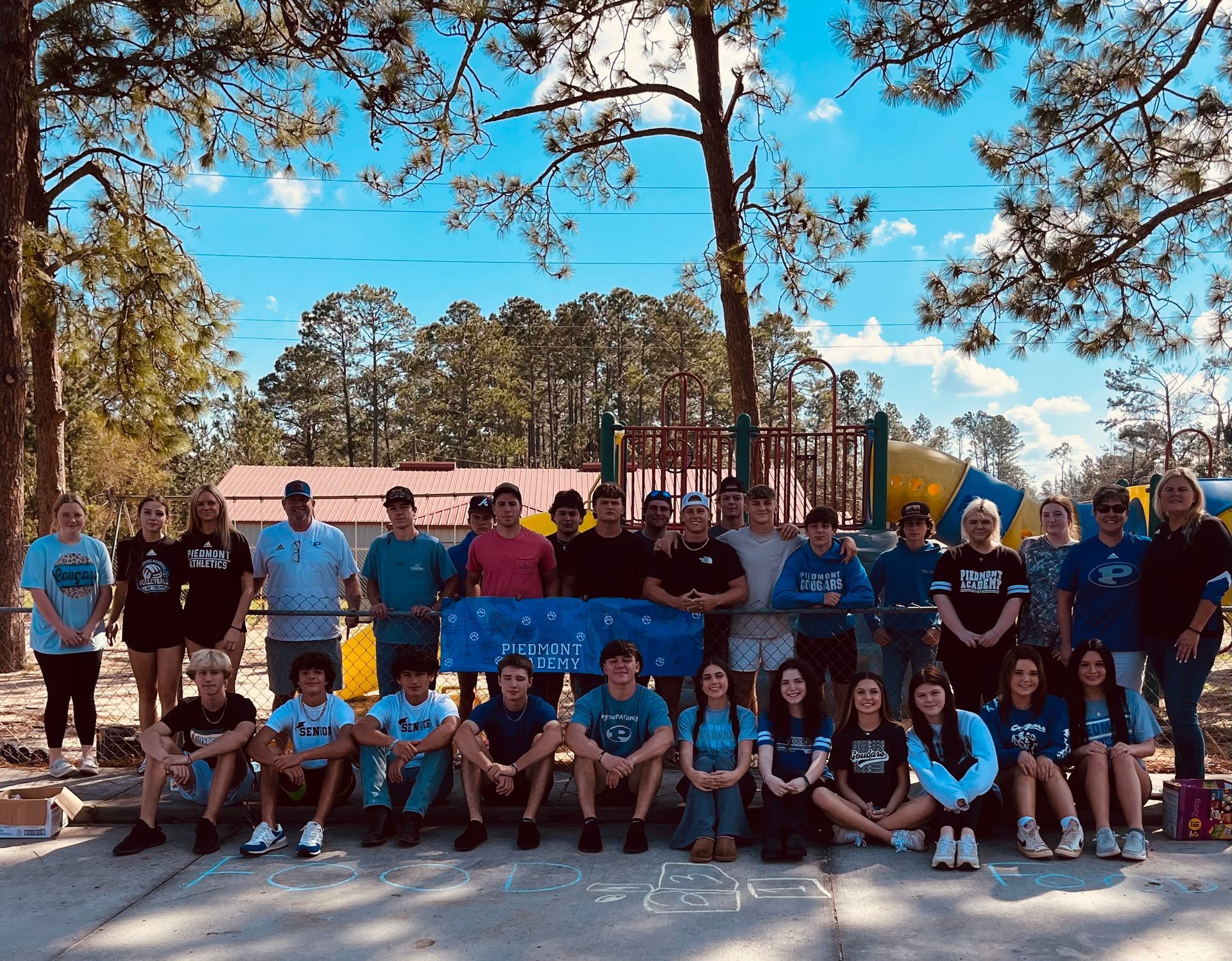 A group of people are posing for a picture in front of a playground.