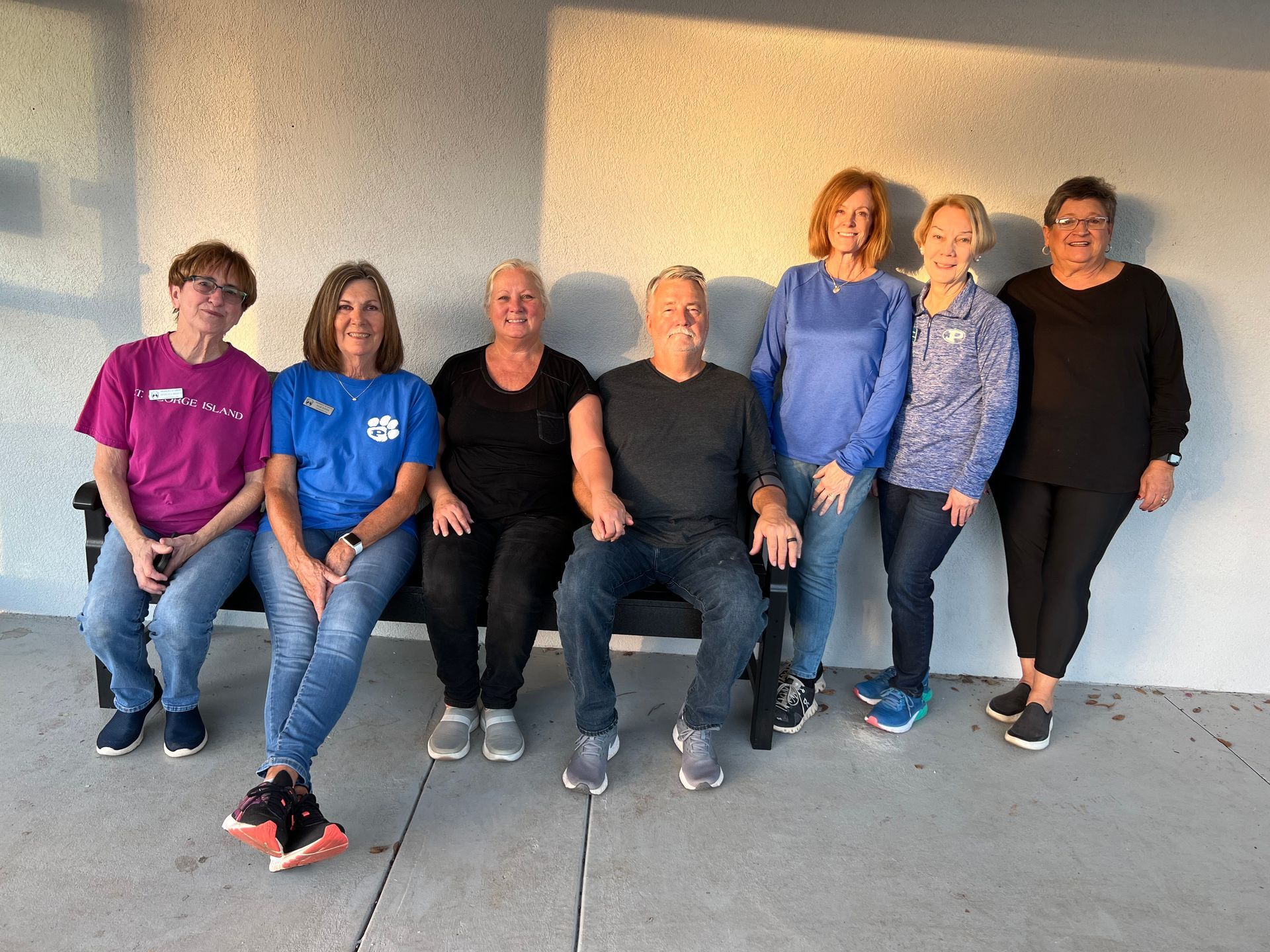 A group of people are posing for a picture in front of a house.