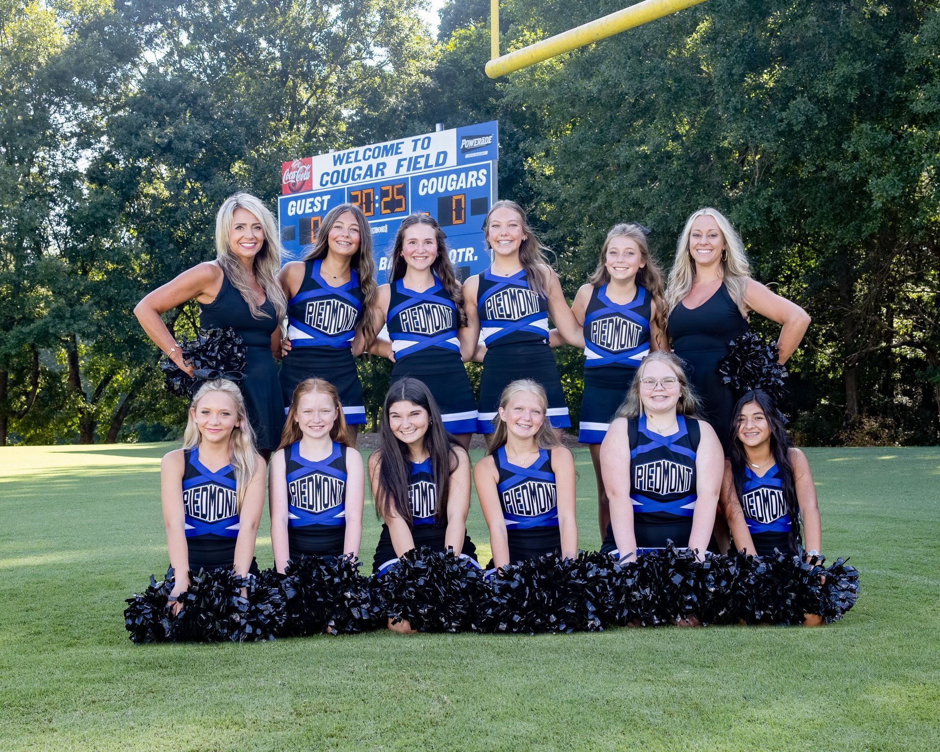 A group of cheerleaders are posing for a picture.