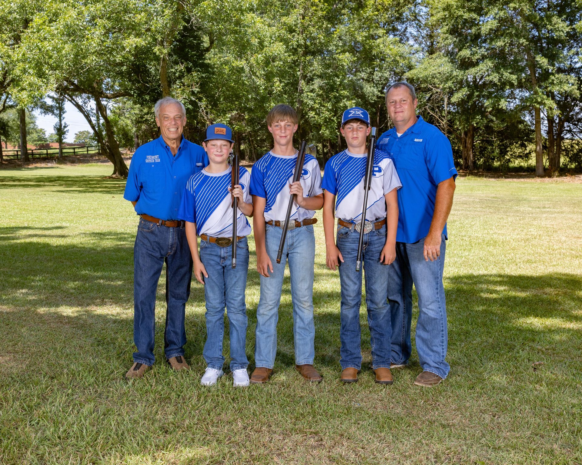 A group of boys are posing for a picture in front of a black background.