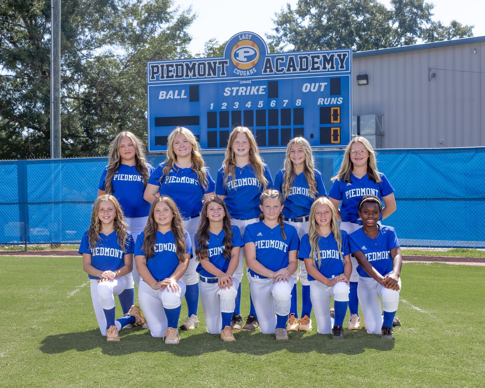 The piedmont softball team is posing for a team photo.